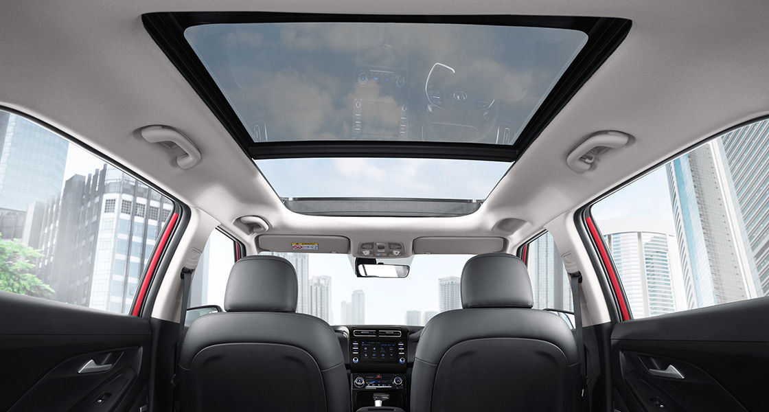 Interior Hyundai Creta menampilkan desain modern dengan kursi kulit abu-abu dan sunroof panoramik yang menghadap langit kota