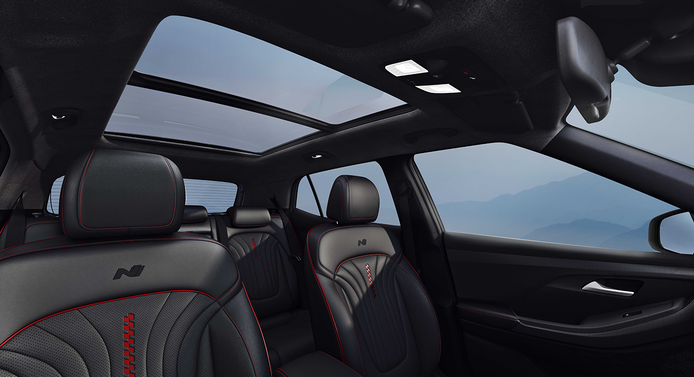 Interior Hyundai Creta menampilkan desain modern dengan kursi kulit abu-abu dan sunroof panoramik yang menghadap langit kota